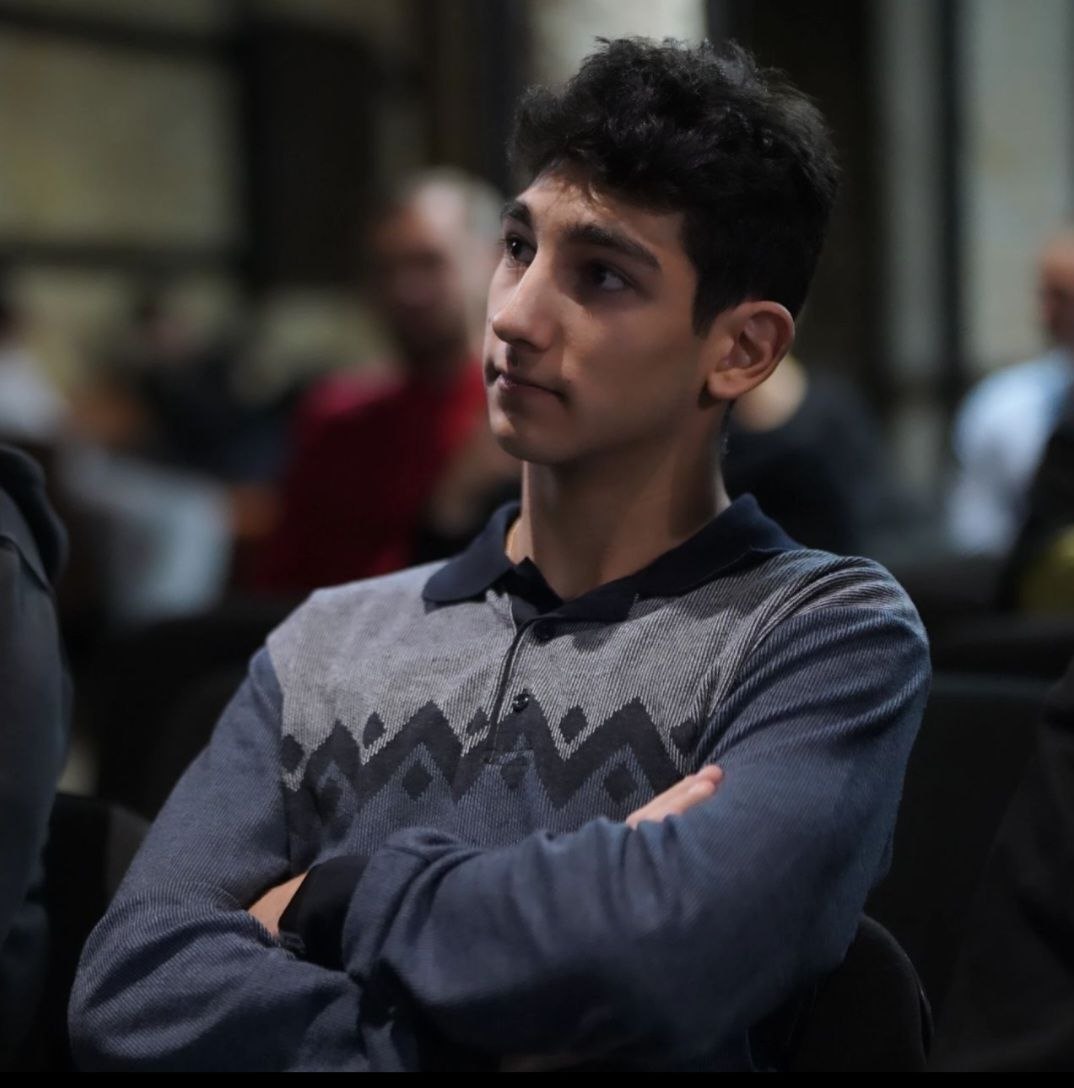 Emil Torosyan, Full-Stack Developer, reviewing code on a laptop in a modern office